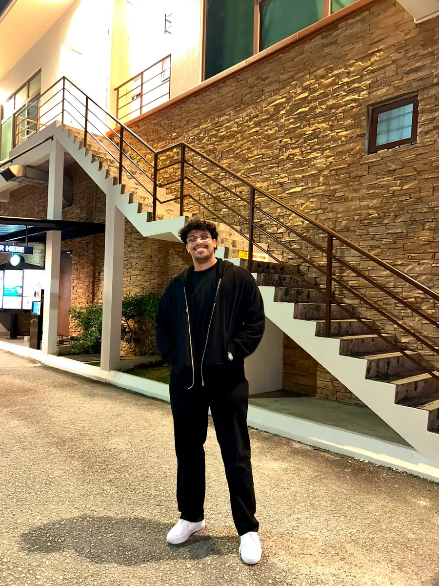 Standing in a university atrium beside a staircase.