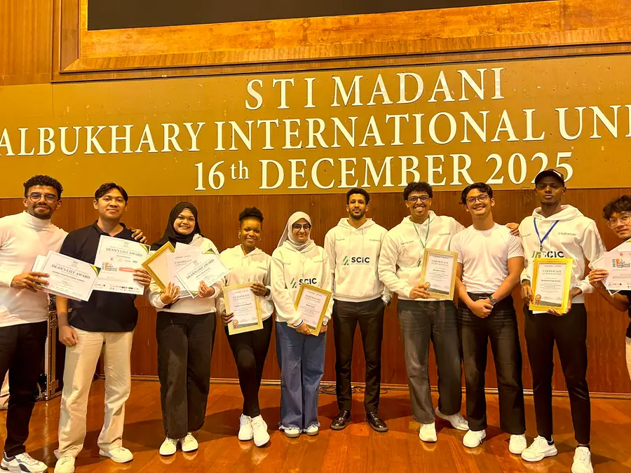 A line of students holding certificates after an STI Madani event.